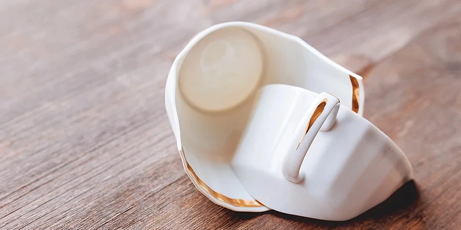 Broken teacup on wooden surface